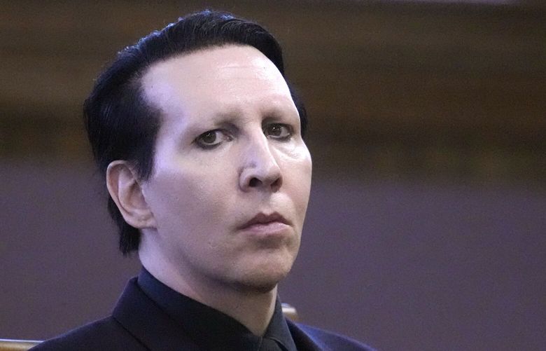 Musical artist Marilyn Manson, whose legal name is Brian Hugh Warner, waits for the judge to arrive in Belknap Superior Court,Monday, Sept. 18, 2023, in Laconia, N.H. Manson, who was charged with charged with two misdemeanor counts of simple assault, was accused of approaching a videographer at his 2019 concert in New Hampshire and allegedly spitting and blowing his nose on her. (AP Photo/Charles Krupa) NHCK107 NHCK107
