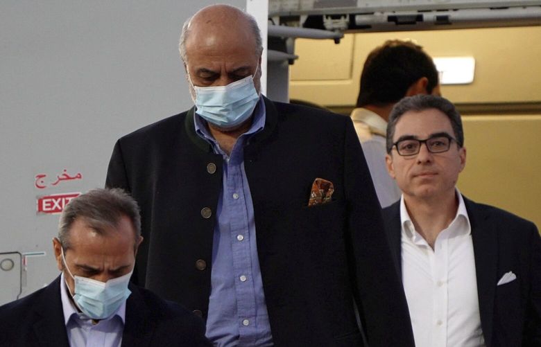 From left, Emad Sharghi, Morad Tahbaz and Siamak Namazi, former prisoners in Iran, walk out of a Qatar Airways flight that brought them out of Tehran and to Doha, Qatar, Monday, Sept. 18, 2023. Five prisoners sought by the U.S. in a swap with Iran were freed Monday and headed home as part of a deal that saw nearly $6 billion in Iranian assets unfrozen. (AP Photo/Lujain Jo) XLJ101 XLJ101