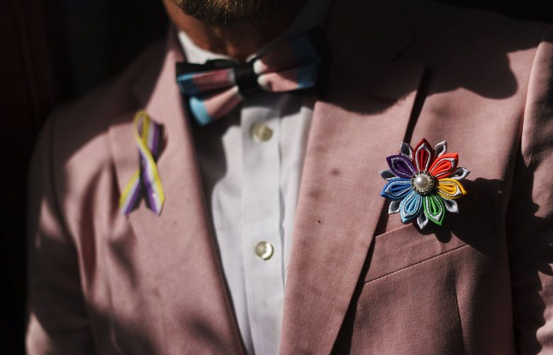 FILE – A rainbow flower sits in the jacket pocket of Scout, a transgender man who uses one name, at his home in Providence, R.I., June 8, 2022. The U.S. Census Bureau on Tuesday, Sept. 19, 2023, asked the Biden administration for permission to test questions about sexual orientation and gender identity for people age 15 and above on its most comprehensive annual survey of life in the U.S. (AP Photo/David Goldman, File) NYSS211 NYSS211