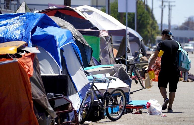 San Diego, CA – May 12: On Thursday, May 12, 2022 in San Diego, CA., Billy Mroczka walks past several tents at a homeless encampment after receiving a fresh supply of new needles and sterile alcohol pads. Mroczka a drug user plans on meeting with Tara Stamos-Buesig at his tent so that she can test samples of his drugs to determine if it contains Fentanyl, heroin or Ketamine Stamos-Buesig is the executive director of On Point, a mobile syringe service and harm reduction program in San Diego. (Nelvin C. Cepeda / The San Diego Union-Tribune) 90482716P