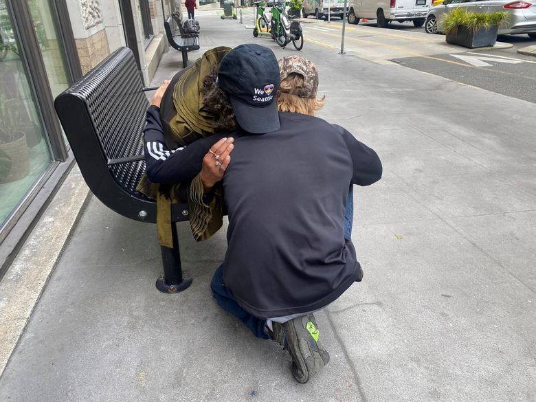 Tim Emerson of We Heart Seattle hugs a woman who was living unsheltered. We Heart Seattle cleaned her subsidized apartment that was unlivable because of excess clutter. The organization also helped her access opioid treatment. (Andrea Suarez)