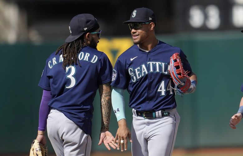 Seattle Mariners’ J.P. Crawford (3) celebrates with Julio Rodriguez (44) after the Mariners defeated the Oakland Athletics in a baseball game in Oakland, Calif., Wednesday, Sept. 20, 2023. (AP Photo/Jeff Chiu) OAS123 OAS123