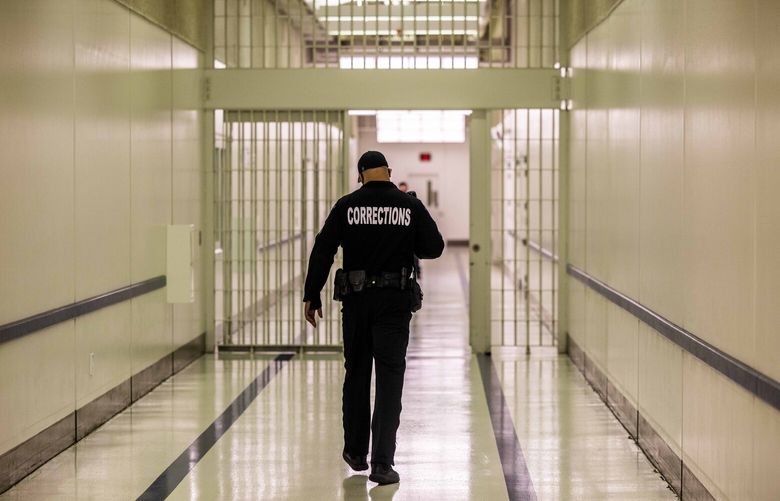 A corrections officer walks down a hallway at SCORE, a jail in Des Moines on Tuesday, Feb. 1, 2022.