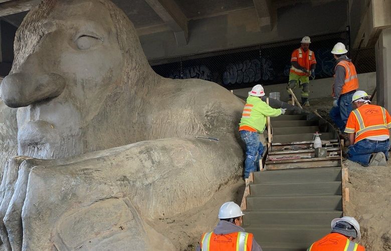 Seattle Department of Transportation crew installs new stairs next to the Fremont Troll, Sept. 21, 2023, in Seattle.