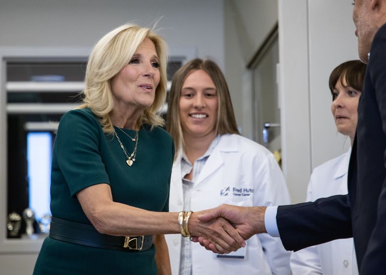 First lady Jill Biden shakes hand with Cyrus Ghajar, public health researcher, as she visits and tours a lab at Fred Hutchinson Cancer Center on Friday. As part of the Biden administration’s Cancer Moonshot efforts, Biden highlighted the importance of supporting cancer survivors through specialized care and research, including survivors of childhood  and breast cancers. (Luke Johnson / The Seattle Times)