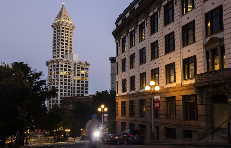 A biker travels along Yesler Way in the early morning hours near Smith Tower on Aug, 4, 2023.