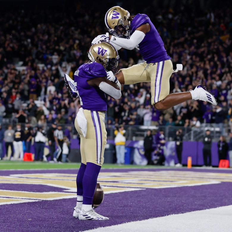 Washington Huskies cornerback Jabbar Muhammad leaps up to celebrate with linebacker Edefuan Ulofoshio after Ulofoshio returned an interception for a touchdown during the first quarter against Cal Bears, Saturday, in Seattle. (Jennifer Buchanan / The Seattle Times)