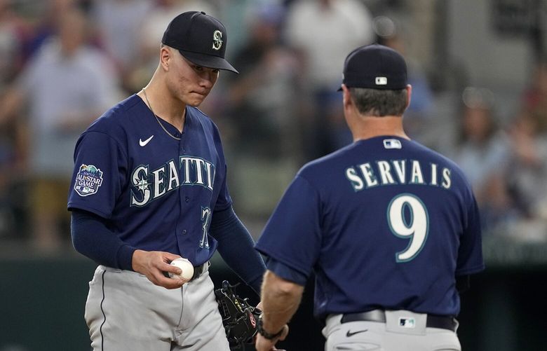 Seattle Mariners starting pitcher Bryan Woo, left, turns the ball over to manager Scott Servais (9) in the fourth inning of a baseball game against the Texas Rangers, Sunday, Sept. 24, 2023, in Arlington, Texas. (AP Photo/Tony Gutierrez)