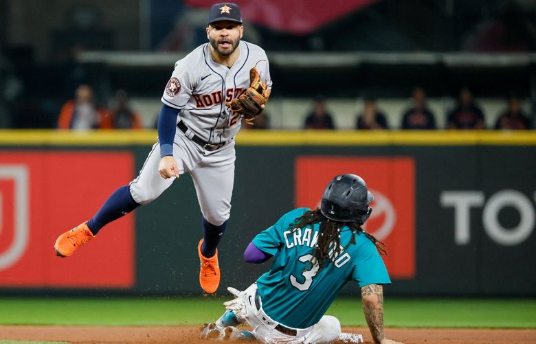 Houston Astros second baseman Jose Altuve leaps out of the way of a sliding J.P. Crawford as the Astros complete the inning ending double play in the third Monday, Sept. 25, 2023 in Seattle. 225046