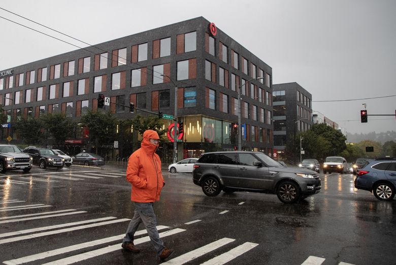 A person crosses the street in front of the Target in Ballard on Tuesday, Sept. 26, 2023. The store is one of two locations in Seattle that are set to close due to break-ins and robberies. (Luke Johnson / The Seattle Times)