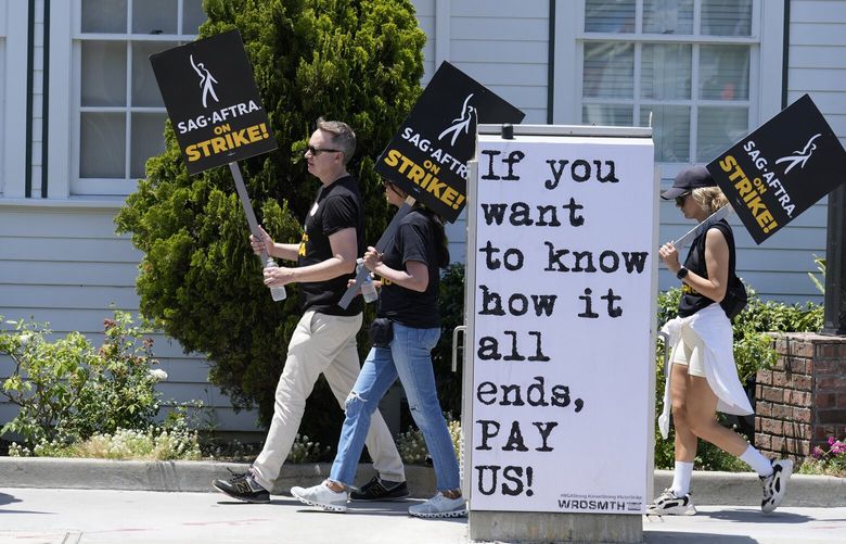 FILE – Picketers carry signs outside Amazon Studios in Culver City, Calif. on Monday, July 17, 2023. A tentative agreement between striking screenwriters and Hollywood studios offers some hope that the industry’s dual strikes may be over soon. (AP Photo/Chris Pizzello, File) GAAK105 GAAK105