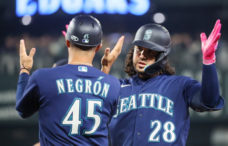 Seattle Mariners third baseman Eugenio Suarez celebrates his 2 RBI single with Seattle Mariners first base coach Kristopher Negrón in the fourth inning Wednesday night at T-Mobile Park in Seattle, Washington on September 27, 2023. 225049
