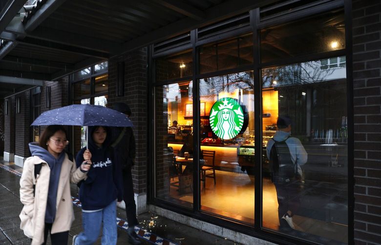 Pedestrians walk past a Starbucks store  in Seattle on November 22, 2022. 