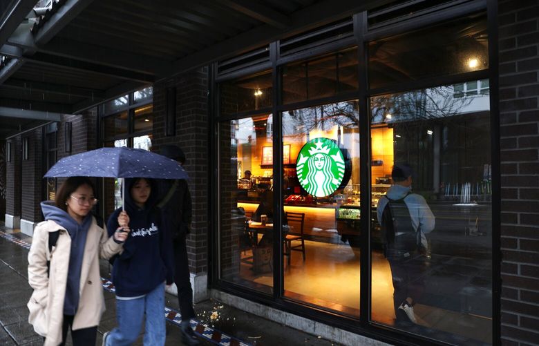 Pedestrians walk past a Starbucks store in Seattle on November 22, 2022.