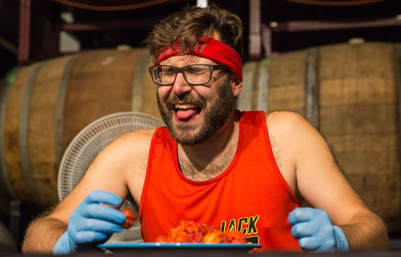 Mike Jack finishes one of the 135 Carolina Reaper peppers that he scarfed down on Nov. 5, 2022, at Forked River Brewing Company in London, Ontario. MUST CREDIT: Monique Wiendels