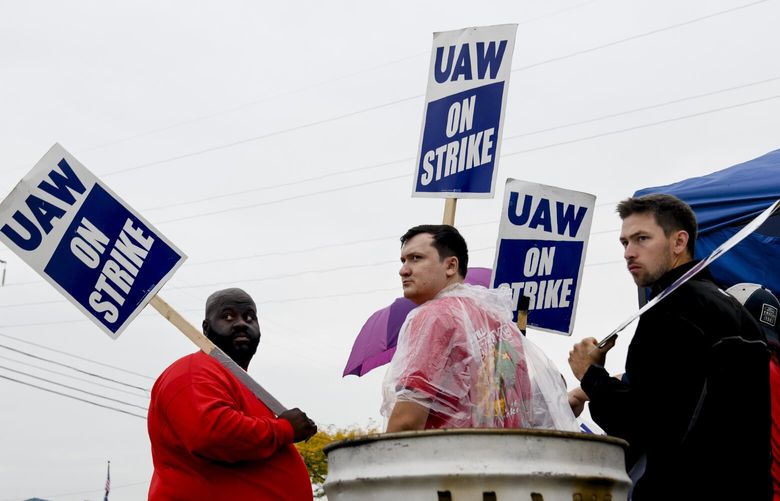 Members of the United Automobile Workers gather for a brief meeting with their strike captain outside of the Ford Michigan Assembly Plant in Wayne, Mich., Sept. 26, 2023. The UAW union said more of its members would walk off the job two weeks after it began strikes at the three large U.S. automakers. (Brittany Greeson/The New York Times) XNYT0861 XNYT0861