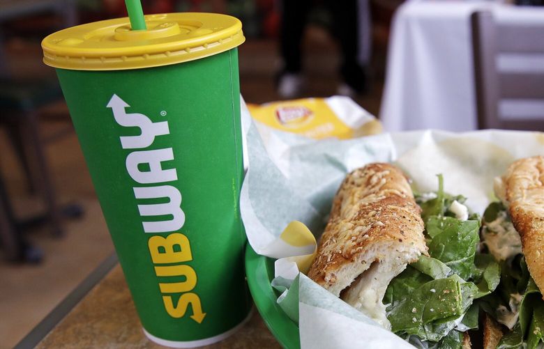 The Subway logo is seen on on a soft drink cup next to a sandwich in 2018. 
(AP Photo/Charles Krupa)