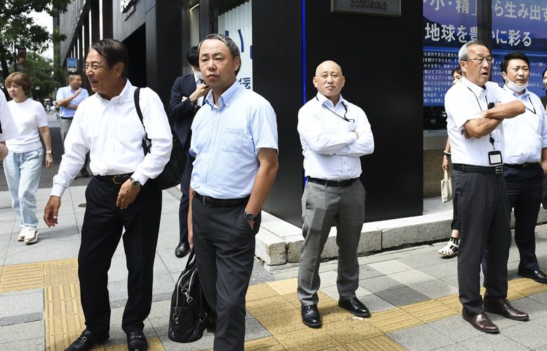Office workers in a business district of Tokyo on Sept. 12, 2023. Under “Cool Biz,” salarymen and government workers don short-sleeved shirts in the summer as offices are kept above 82 degrees Fahrenheit to save energy. (Noriko Hayashi/The New York Times) 