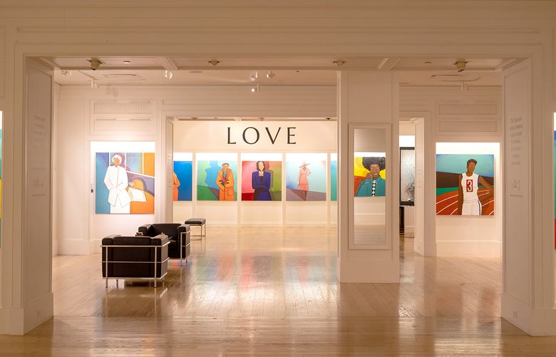 An exhibit on display at WOW Gallery. Portraits of Black women line the walls along with the word "Love" on the far back wall