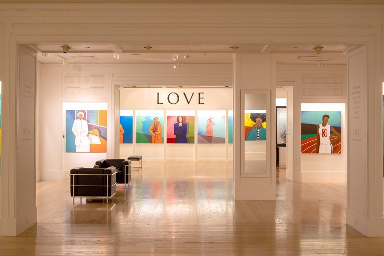 An exhibit on display at WOW Gallery. Portraits of Black women line the walls along with the word "Love" on the far back wall