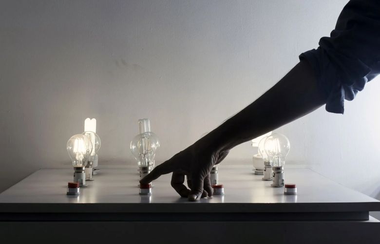 A worker demonstrates various LED lightbulbs. (Udit Kulshrestha/Bloomberg)