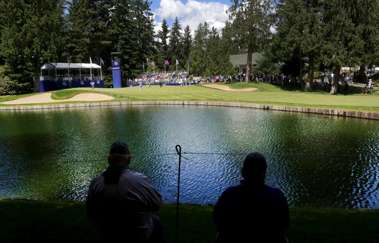 Norman Abbott, left, and his wife, Janet Nelson, watch competitors from across the lake on the 9th hole on day two of the KPMG Women’s PGA Championship on Friday, June 10, 2016, at Sahalee Country Club in Sammamish.