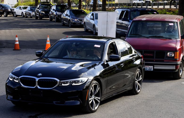Cars line up for a discounted-gas event in September at a Kent filling station. (Ken Lambert / The Seattle Times)