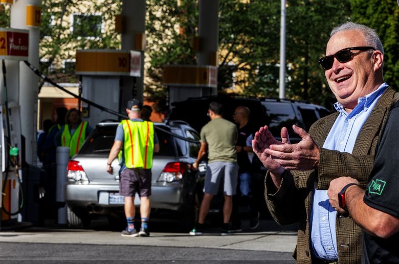 State Rep. Jim Walsh, R-Aberdeen, the state Republican Party chairman, is in a good mood as cars line up for the Future 42 and Americans for Prosperity low-price gas event last month in Kent. (Ken Lambert / The Seattle Times)