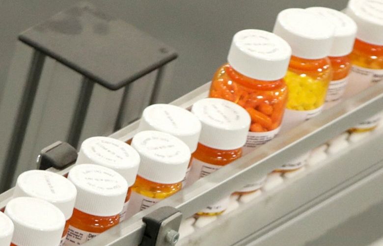 FILE- Bottles of medicine ride on a belt at a mail-in pharmacy warehouse in Florence, N.J., July 10, 2018. The Biden administration says the manufacturers of all of the first 10 prescription drugs it selected for Medicare’s first price negotiations have agreed to participate. Tuesday’s announcement clears the way for talks that could lower their costs in coming years and gives the White House a potential political win heading into next year’s presidential election. (AP Photo/Julio Cortez, File) WX102 WX102