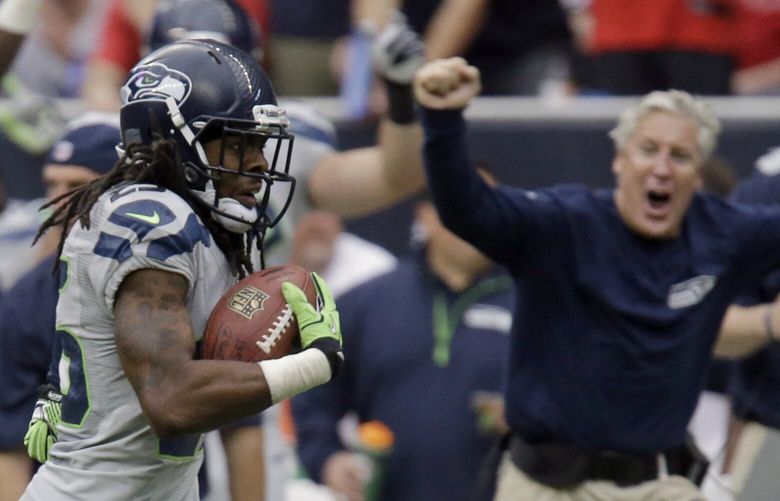 Seattle Seahawks cornerback Richard Sherman returns an interception for a touchdown as coach Pete Carroll, right, cheers from the sideline during the fourth quarter an NFL football game against the Houston Texans Sunday, Sept. 29, 2013, in Houston. (AP Photo/Patric Schneider) HTT1