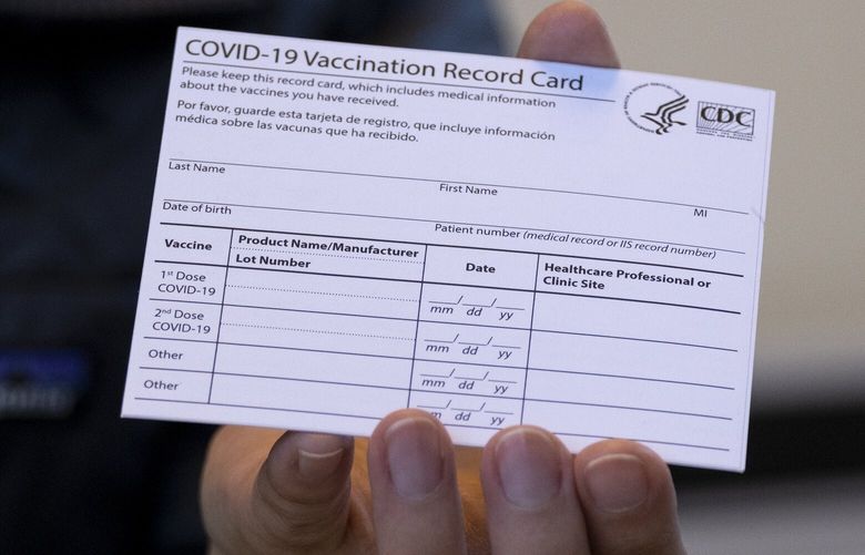 FILE – A nurse practitioner holds a COVID-19 vaccine card at a New York Health and Hospitals vaccine clinic in the Brooklyn borough of New York on Jan. 10, 2021. Now that COVID-19 vaccines are being distributed through the commercial markets instead of by the federal government in 2023, the Centers for Disease Control and Prevention won’t be shipping out any more new cards. (AP Photo/Craig Ruttle, File) NY778 NY778
