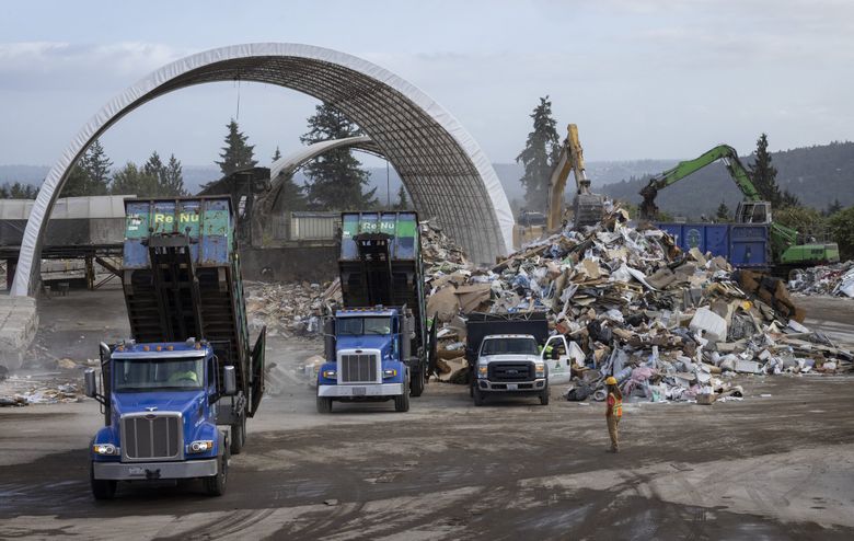Trucks dump their loads for sorting and processing at DTG Recycle in Snohomish. The company processed 900,000 tons of construction and demolition waste at its various facilities last year. But much of the material is unusable and ends up in landfills. (Ellen M. Banner / The Seattle Times)