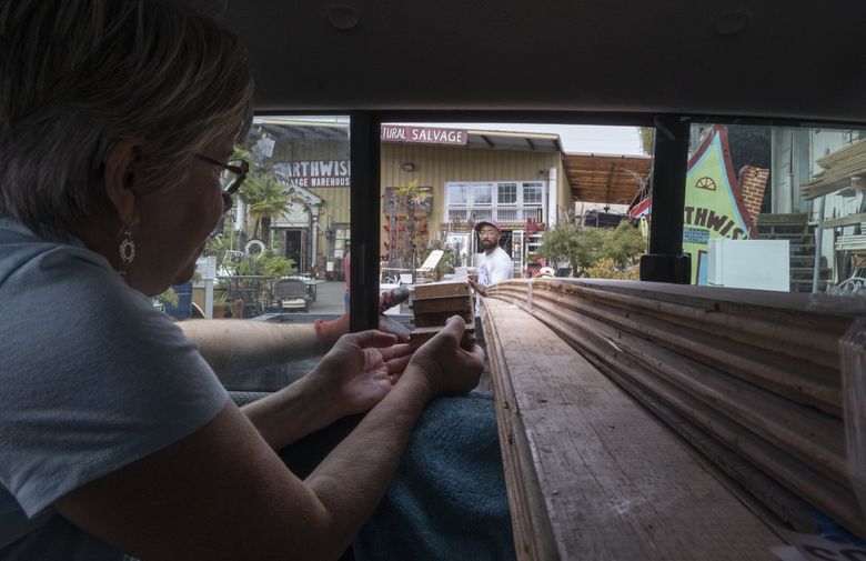 Acton Seibel helps Beth Husted of Arlington load flooring she and her husband, Greg Husted, purchased at Earthwise Architectural Salvage in Seattle’s Sodo neighborhood. The Husteds own a 1902 house, and salvage is the only source for the clear, old-growth fir they want for their new primary bedroom. (Ellen M. Banner / The Seattle Times)