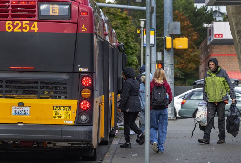 People board the RapidRide E bus to downtown Seattle during the morning commute from Aurora Village Transit Center in Shoreline. (Ken Lambert / The Seattle Times)