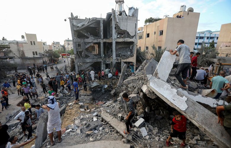 People survey the destruction after an Israeli airstrike on Khan Younis in Gaza on Tuesday, Oct. 17, 2023. President Joe Biden is expected to visit Israel on Wednesday as pressure mounts to provide safety and aid to hundreds of thousands of Palestinians in Gaza who have fled their homes before a likely Israeli invasion. (Yousef Masoud/The New York Times)