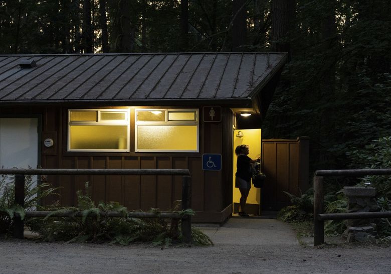 Cierra Audet exiting the bathroom at Bridle Trails State Park in Redmond, Wash., where she and her mother have been showering while sleeping in their car, on Aug. 27.  (Ruth Fremson / The New York Times) 