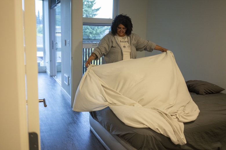 On Sept. 23, Chrystal Audet prepares an air mattress in her new one-bedroom apartment in Redmond, Wash., which she and her daughter moved into after sleeping in their car for three months. She is relishing the ability to stretch out when she sleeps. (Ruth Fremson / The New York Times)