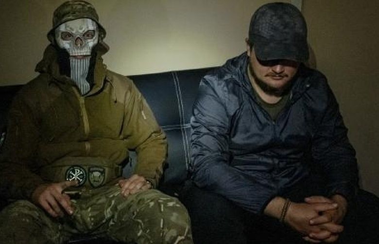 Ukrainian commandos known as Kukhar, left, 23, and Askold, 38, who conceal their identities, in a bare office used as a safe house in Kyiv, Ukraine, on Oct. 5, 2023. Inside the commando raids unnerving Russia in Crimea; the lightning assaults are part of a larger campaign using drones and missiles to degrade Russian forces and demoralize the public. (Nicole Tung/The New York Times) XNYT0454 XNYT0454