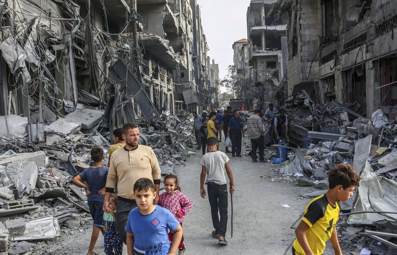 People inspect buildings destroyed by Israeli airstrikes at the Nuseirat Market in the Gaza Strip, Monday, Oct 23, 2023. (Samar Abu Elouf/The New York Times) XNYT0415 XNYT0415
