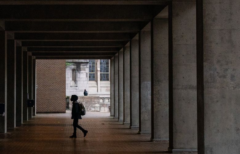A student walks to UW’s Kane Hall on a gray and rainy Monday, Nov. 7, 2022. The Seattle area is facing unseasonably near-freezing temperatures this week. (Kylie Cooper / The Seattle Times)
