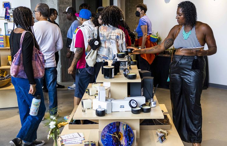 Nyasha Sarju looks at the Blessed & Thankful candles being sold at Arte Noir in the Central District on opening day, September 17, 2022. Arte Noir sells limited edition candle scents in stores.