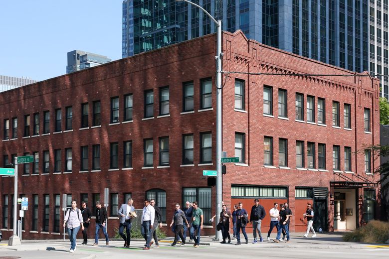 Office workers walk at Seventh Avenue and Lenora Street, just south of the Amazon Spheres. (Kevin Clark / The Seattle Times)