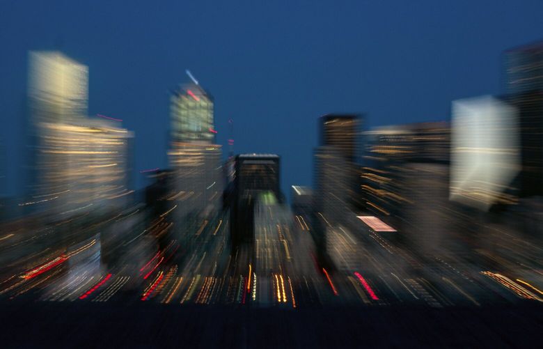 A slow shutter speed captures the lights of downtown Seattle at twilight on Saturday, Dec. 3, 2022.