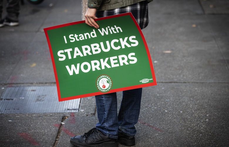 A mix of Starbucks employees from other stores and labor supporters show solidarity outside the Starbucks at First and Pike, part of a nationwide strike early Thursday morning, although this is not a striking store, it is open and no employees walked out, Thursday, Nov. 16, 2023 in Seattle.