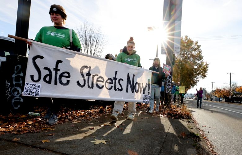 Colleen Kaminski, left, and Silvia Wagner lead a group concerned about traffic deaths involving pedestrians along Aurora Avenue as part of the World Day of Remembrance for Victims of Traffic on Saturday. The walk was organized by the Aurora Reimagined Coalition. (Karen Ducey / The Seattle Times)