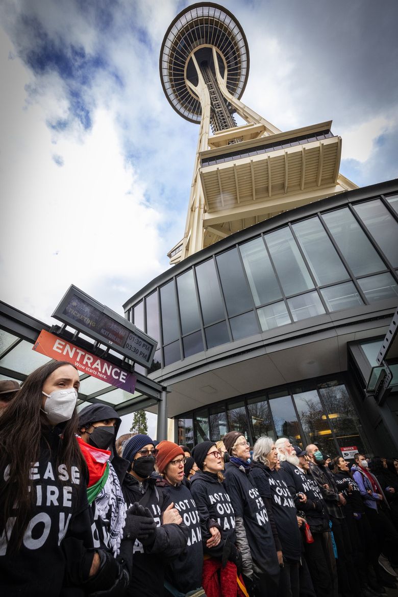 Hundreds of protesters supporting Palestinians block the entrance and ticket purchasing area to the Space Needle, demanding a cease-fire in the Israel-Hamas war, Sunday in Seattle. (Ken Lambert / The Seattle Times)