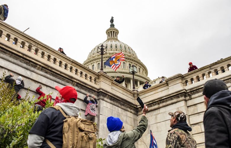 FILE — A mob of supporters of former President Donald Trump climb the walls outside the Capitol in Washington, Jan. 6, 2021. Speaker Mike Johnson’s decision to publicly release thousands of hours of Capitol security footage from Jan. 6, 2021, has fueled a renewed effort by Republican lawmakers and far-right activists to rewrite the history of the attack that day and exonerate the pro-Trump rioters who took part. (Jason Andrew/The New York Times) XNYT0062 XNYT0062