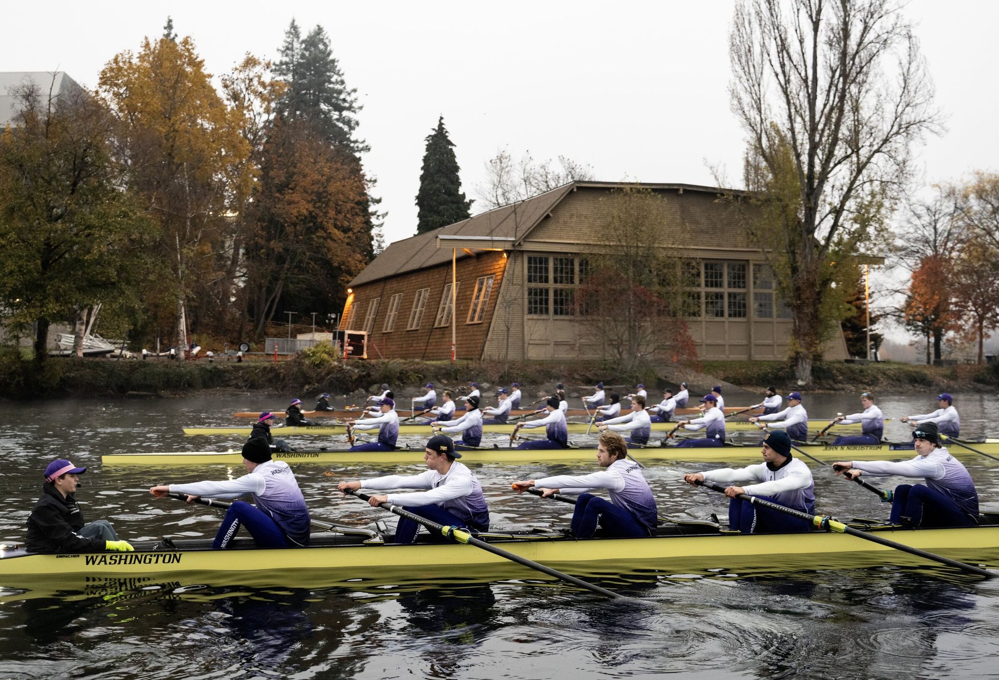 Happy caucasian male rowing team wearing sunglasses in boat on