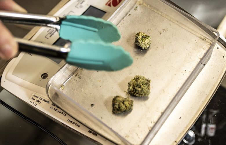 FILE — An employee weighs out medical marijuana at G&C Dispensary in Keota, Okla. on Dec. 9, 2021. Medical marijuana is now legal in most states. (Brett Deering/The New York Times) XNYT0038 XNYT0038