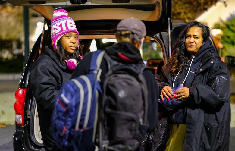 Toshua Henry, left, and Meli Paulo offer hand warmers and snacks to a man named Chris who sought them out at the Burien Transit Center.  The two women are part of an outreach program run by Metro for people who are homeless, or in crisis. 225560